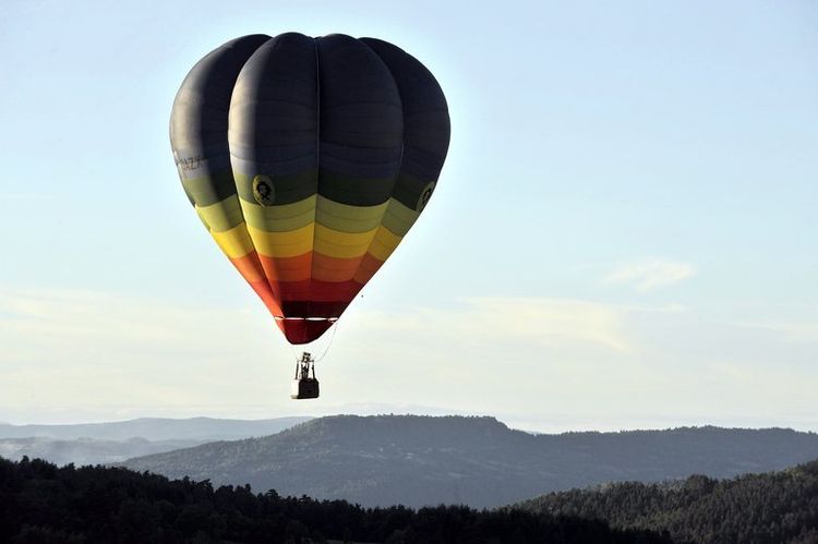 Une montgolfière dépasse des montagnes à haute altitude
